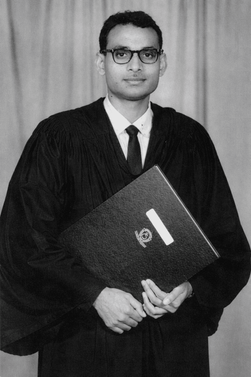 Young Professor Madiraju Ranga Rao in graduation attire holding his degree folder